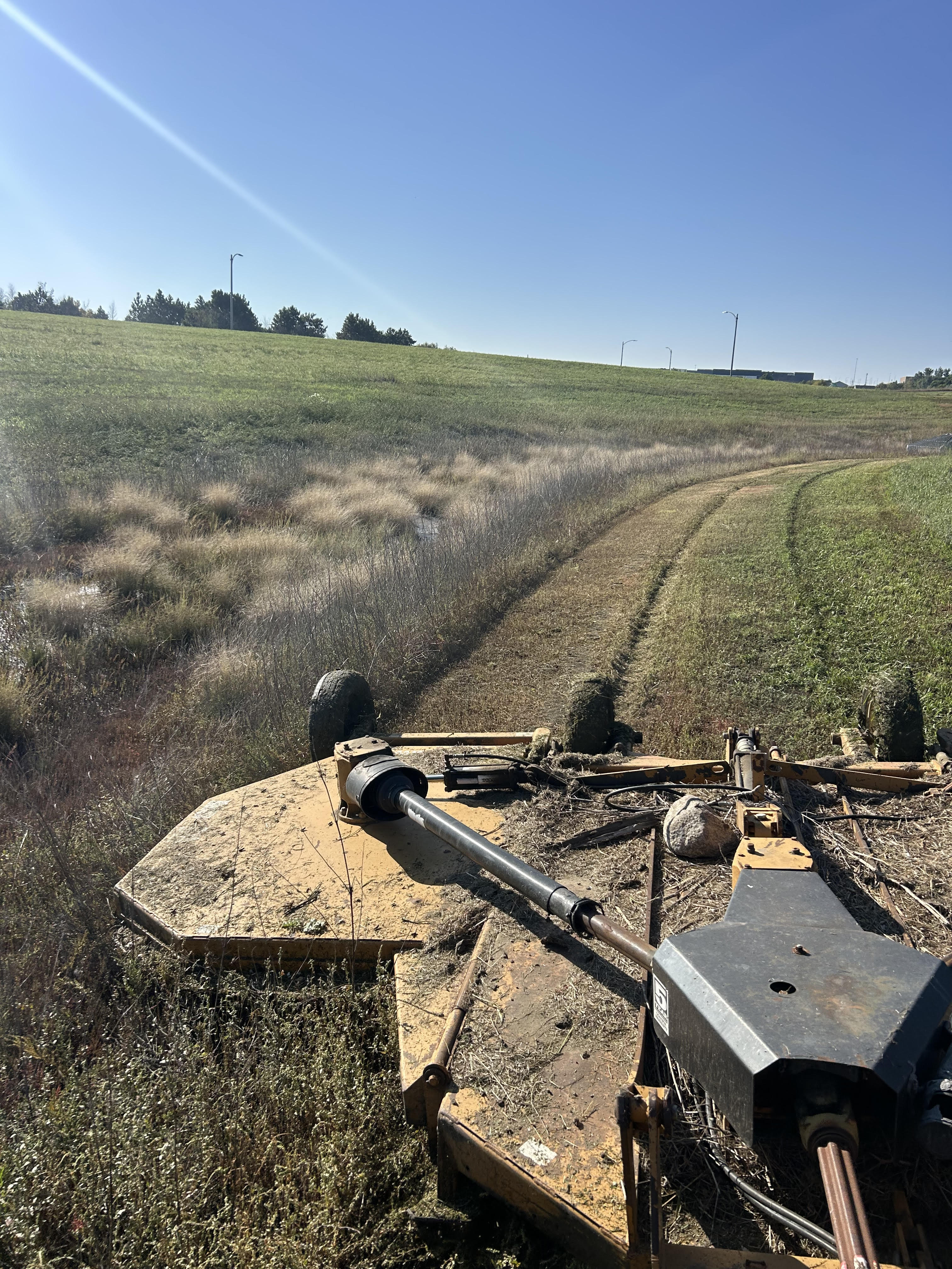 Industrial brush mower clearing overgrown field in North Dakota